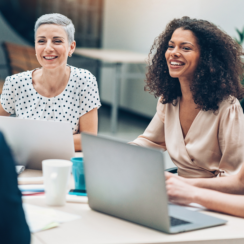 Two women smile during a meeting